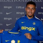 Morgan Rogers pose avec le maillot de Chelsea après son transfert record depuis Aston Villa