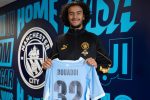 Ayyoub Bouaddi pose avec le maillot de Manchester City floqué 32 lors de sa présentation officielle