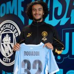 Ayyoub Bouaddi pose avec le maillot de Manchester City floqué 32 lors de sa présentation officielle