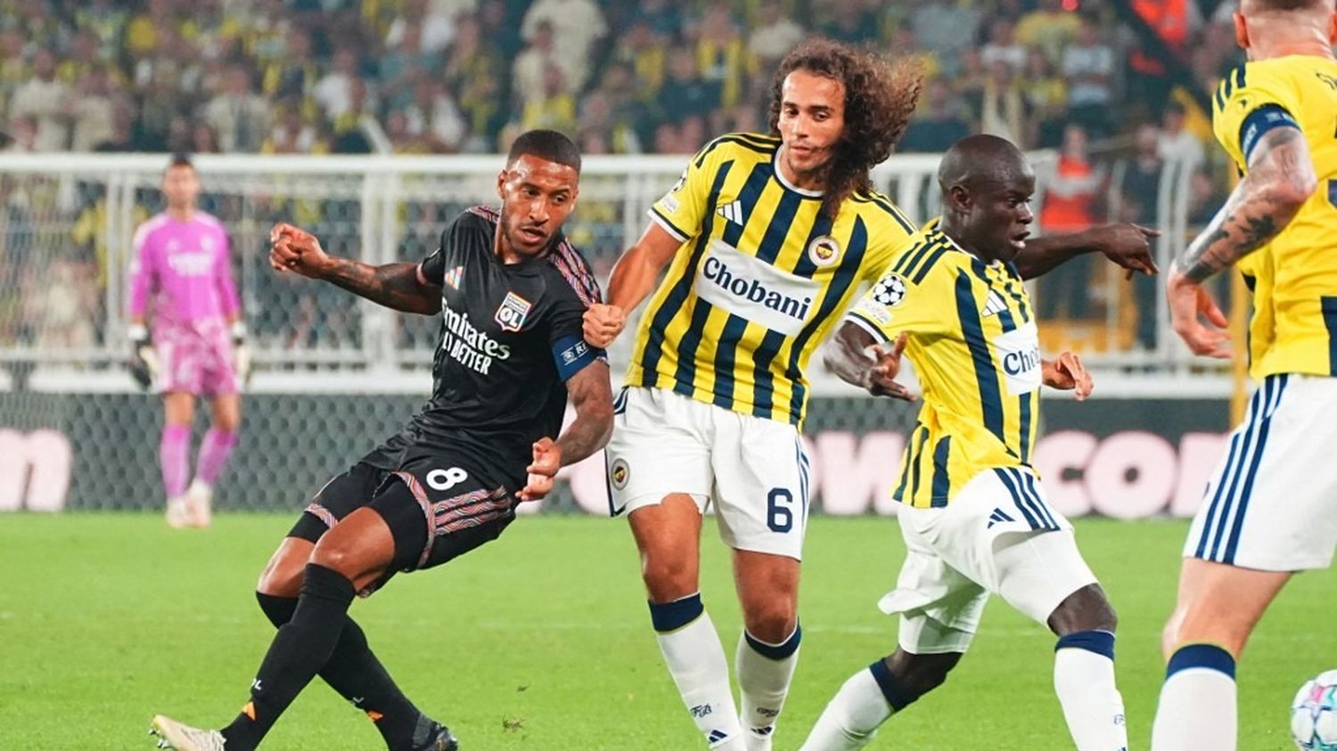 Duel entre un joueur de Lyon et des joueurs de Fenerbahçe lors du barrage de Ligue des champions 2026