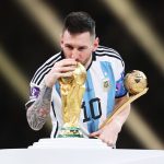 Lionel Messi embrasse le trophée de la Coupe du monde avec le maillot argentin
