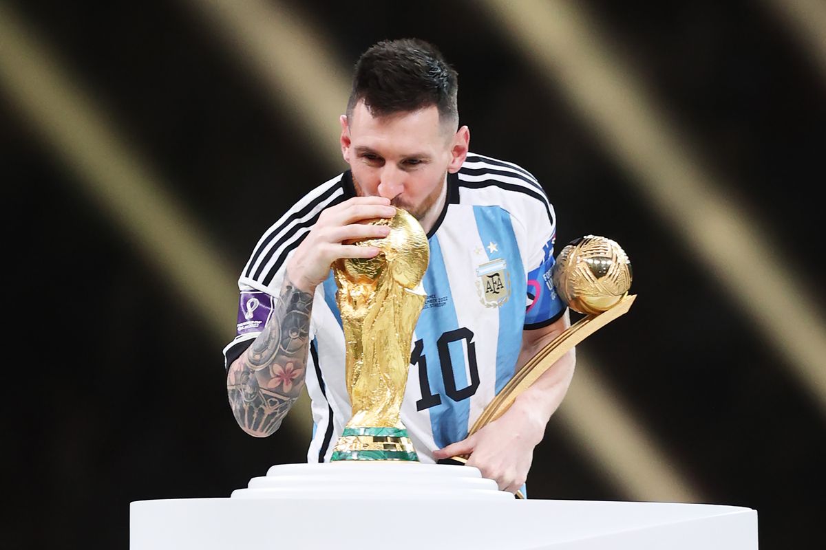 Lionel Messi embrasse le trophée de la Coupe du monde avec le maillot argentin